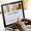 A closeup of a person looking for a job using a laptop
