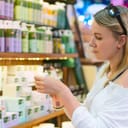 Young woman selecting cosmetic cream in a beauty store