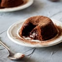 Chocolate flowing from a lava cake served on a plate