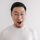 A man in white t-shirt isolated on white wall making a funny grimace