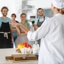 Group of people and female chef at cooking classes