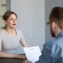 female job applicant looks surprised and stressed during an interview, panicking over an unexpected question 