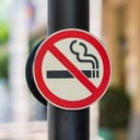 A "No Smoking" sign against a blurry background.