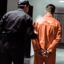 Prisoner getting escorted by a correctional officer