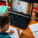 schoolboy engaged in distance learning online education at home with a laptop in front of him on the desk