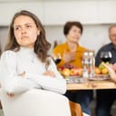 upset young woman at a family holiday dinner with parents, turned away