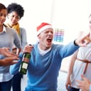 A drunk person holding a bottle of wine and yelling while the rest of the people look at him
