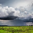 Black, rainy clouds approaching with storm far away in the background
