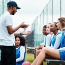 A netball coach outlines game strategies to the team, emphasizing teamwork and collaboration.