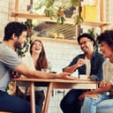 Young friends having a great time in restaurant. Group of young people sitting in a coffee shop and smiling