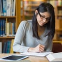 black-haired woman focused on studying in a library