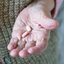 A senior woman holding pills in her hand