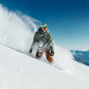 A person riding a snowboard down a slope