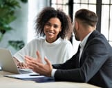 Two people in business setting amicably conversing