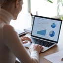 A woman looking at data on laptop