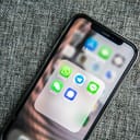 An iPhone with a folder with social messaging apps