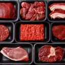 A selection of red meat products placed in different black containers