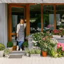 Woman florist and small business owner standing at the door of her flower shop