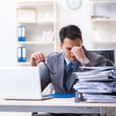 Stressed out businessman holding his head in pain