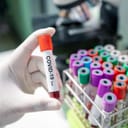 Person holding a COVID-19 test tube