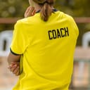 A female coach in a yellow t-shirt