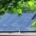 Close-up of solar panels mounted on the rooftop of a contemporary house.