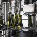 an industrial machine fills bottles with wine for distribution in a Sicilian wine factory in Italy