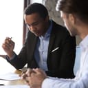 young male businessman carefully checking the contract before signing it