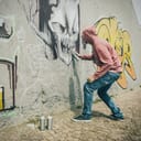 Man drawing a graffiti on the wall