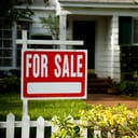 'For sale' picket sign in front of a house
