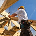 A construction worker nailing a wooden board