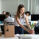 A happy young woman unpacking her stuff at a new job