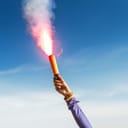 A person holding a lit flare