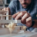 Man adjusting a house model