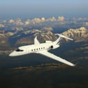 A small private jet flying in the sky