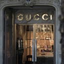 Entrance to a Gucci store with the Gucci name in gold, backlist letters