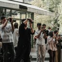 A big group of paparazzi gathered in front of a building, with their cameras ready.