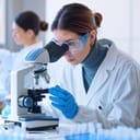 Young scientists conducting research investigations in a medical laboratory, a researcher in the foreground is using a microscope
