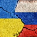 Ukraine and Russia flags on cracked concrete
