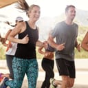 A group of smiling young people running together