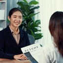 Female recruiter interviewing one candidate, discussing her CV and application during a job interview.