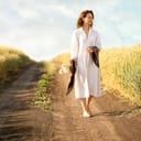 woman walking down a path through a wheat field
