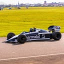 a man driving a race car down a road