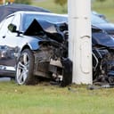 close-up of a vehicle crash with car colliding into a light pole