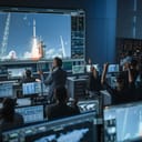 Mission control center staff applaud successful rocket launch. 