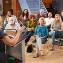 community members at a neighborhood meeting in a community center, listening to a speaker