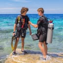 two young scuba divers checking their equipment before a dive