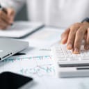 close-up of a bookkeeper managing finances and calculations with the help of a calculator.