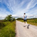 A person running down a gravel road