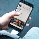 A person holding their phone and checking their Instagram account